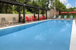 圣奥古斯丁Home2 Suites By Hilton St. Augustine I-95的一个带桌椅和遮阳伞的游泳池