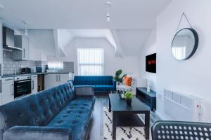 LitherlandBeautiful apartment una的客厅配有蓝色的沙发和桌子