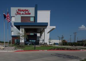邓肯维尔Hampton Inn & Suites Duncanville Dallas, Tx的前面有一个带有美国国旗的购物中心
