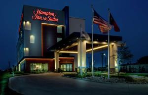 邓肯维尔Hampton Inn & Suites Duncanville Dallas, Tx的前面有两面美国国旗的酒店