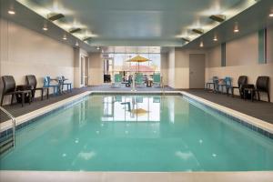 比弗克里克Home2 Suites By Hilton Dayton/Beavercreek, Oh的大楼内一个带桌椅的游泳池