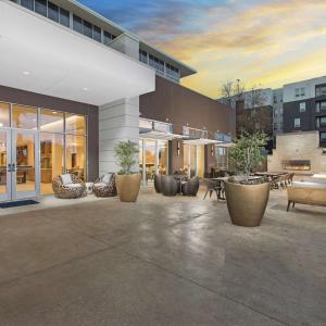 圣安东尼奥DoubleTree by Hilton San Antonio Northwest - La Cantera的一座带桌椅的庭院的建筑