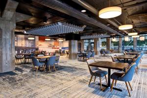 罗克福德Embassy Suites By Hilton Rockford Riverfront的餐厅设有木桌、椅子和窗户。