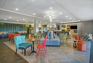 罗维莎Home2 Suites By Hilton Lawrenceville Atlanta Sugarloaf, Ga的一间设有五颜六色的椅子和桌子的等候室