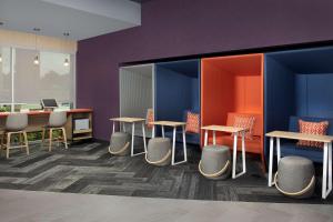 夏洛特Tru By Hilton Charlotte Airport Lake Pointe的一个带桌椅和紫色墙壁的办公室