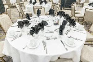 威奇托Hilton Garden Inn Wichita Downtown, Ks的一张桌子,用于婚礼,上面有白色的桌子和黑色的餐巾纸