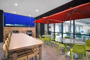利伯蒂Home2 Suites by Hilton Liberty NE Kansas City, MO的一间带桌椅和红伞的餐厅