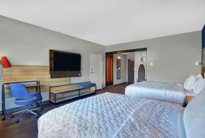 斯普林菲尔德Tru By Hilton Springfield Downtown的酒店客房设有两张床、一张桌子和一台电视。