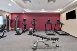 萨拉索塔Home2 Suites by Hilton, Sarasota I-75 Bee Ridge, Fl的健身房设有数辆健身自行车和红色墙壁