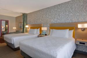 萨拉索塔Home2 Suites by Hilton, Sarasota I-75 Bee Ridge, Fl的两张位于酒店客房的床,配有两张sidx sidx单人床