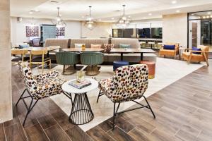 阿尔法利塔Home2 Suites By Hilton Alpharetta, Ga的一个带桌椅的大堂和一间用餐室