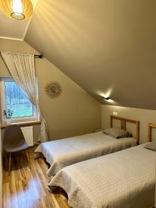 VecumniekiSemo guest house with amazing sauna and pool的一间卧室设有两张床和窗户。