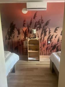 波罗斯洛Pipacs Vendégház的一间卧室设有两张床,墙上有棕榈树