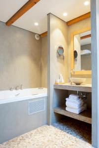 昂蒂布法布里特别墅的一间带水槽、浴缸和镜子的浴室