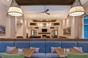 萨默维尔Homewood Suites By Hilton Summerville的一间配备有蓝色沙发和桌子的用餐室