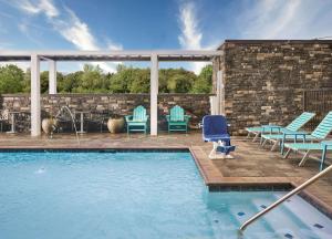 珀尔Home2 Suites By Hilton Jackson/Pearl, Ms的一个带椅子的庭院和一个游泳池