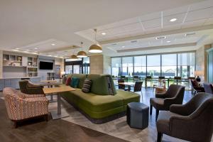 路易斯维尔Home2 Suites By Hilton Lewisville Dallas的大堂设有绿色的沙发和桌椅