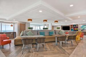 奥蒙德海滩Home2 Suites Ormond Beach Oceanfront, FL的客厅配有沙发和桌椅