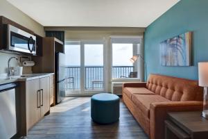 奥蒙德海滩Home2 Suites Ormond Beach Oceanfront, FL的带沙发的客厅和阳台