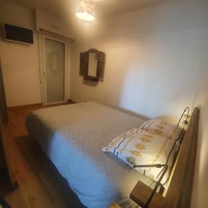 萨尔佐Appartement rez de jardin proche du centre ville de sarzeau的一间带床的卧室,位于带窗户的房间内