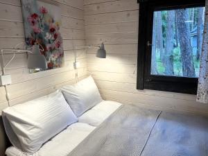 波别罗沃Domki - Sosnowy Las的窗户客房内的一张白色床
