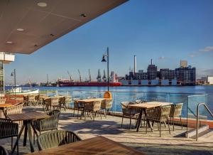 巴尔的摩Canopy By Hilton Baltimore Harbor Point - Newly Built的一个带桌椅的庭院,享有水景