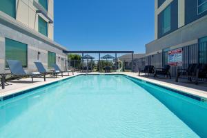 吉尔罗伊Hampton Inn & Suites Gilroy, Ca的一座带椅子的建筑内的游泳池