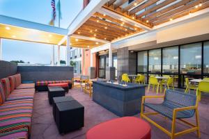 罗斯威尔Home2 Suites by Hilton Roswell, NM的餐厅设有多彩的桌椅和窗户。