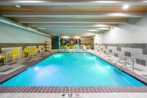 罗斯威尔Home2 Suites by Hilton Roswell, NM的游泳池位于酒店带桌椅的客房内