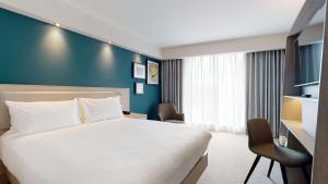 曼彻斯特Hampton By Hilton Manchester Northern Quarter的酒店客房,设有床铺和蓝色的墙壁
