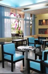 帕拉代西翁罗德阳光酒店 的一间在房间内配有蓝色椅子和桌子的餐厅