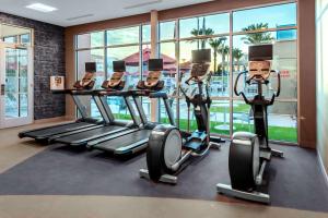 钱德勒Hilton Garden Inn Chandler Downtown的健身房设有心肺功能训练器材和大窗户