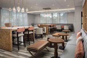 切尔西Hampton Inn Boston Logan Airport Chelsea的餐厅设有酒吧和桌椅