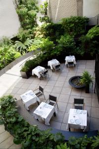 马德里Atocha Hotel Madrid, Tapestry Collection by Hilton的庭院配有白色的桌椅和植物