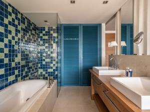 扎达尔法尔肯斯坦纳酒店及亚德拉Spa的浴室设有2个水槽、浴缸和镜子
