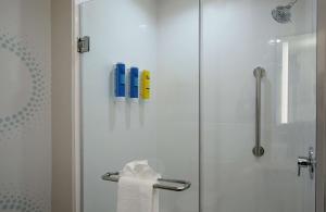 哥伦布Tru By Hilton Columbus Airport的带淋浴的浴室和玻璃门