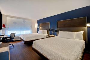 康科德Tru By Hilton Concord, Nh的酒店客房设有两张床和蓝色的墙壁。