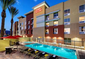 印地欧Hampton Inn & Suites Indio, Ca的一张拥有游泳池和棕榈树的酒店形象