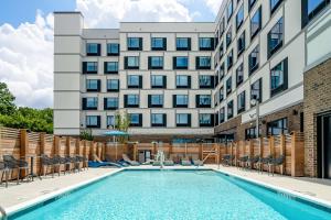 罗利Hampton Inn & Suites Raleigh Midtown, NC的大楼前的游泳池