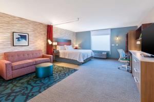 巴特尔克里克Home2 Suites By Hilton Battle Creek, Mi的酒店客房,配有床和沙发