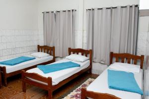 波多韦柳Guajará Palace Hotel的客房内的两张床,上面有蓝色的毛巾
