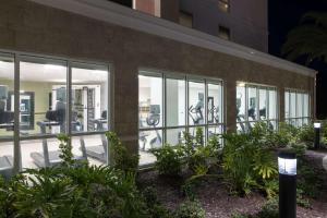 卡纳维拉尔角Home2 Suites By Hilton Cape Canaveral Cruise Port的一座带玻璃窗户、椅子和植物的建筑