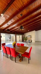 博尼图Recanto das Araras, Transcendental的一间带木桌和红色椅子的用餐室