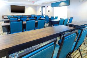 康威Hampton Inn & Suites Conway, Ar的一个配有桌子和蓝色椅子的空教室