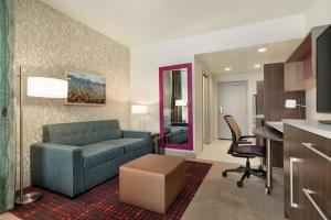 埃夫拉塔Home2 Suites By Hilton Ephrata的一间带蓝色沙发的客厅和一间厨房