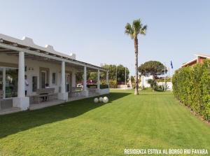 圣玛丽亚德尔法加洛Residenza estiva al Borgo Rio Favara的草坪上带两个球的院子的房子