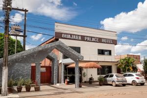 波多韦柳Guajará Palace Hotel的街道上的建筑,前面有汽车停放