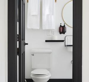 温德姆Eastwind的浴室设有白色的卫生间和镜子