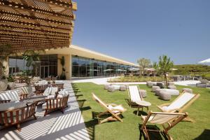 Praia VerdeVerdelago Resort的一座带躺椅和桌子的庭院以及一座建筑
