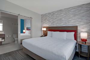 墨尔本Home2 Suites By Hilton Melbourne Viera的一间带大床的卧室和一间浴室